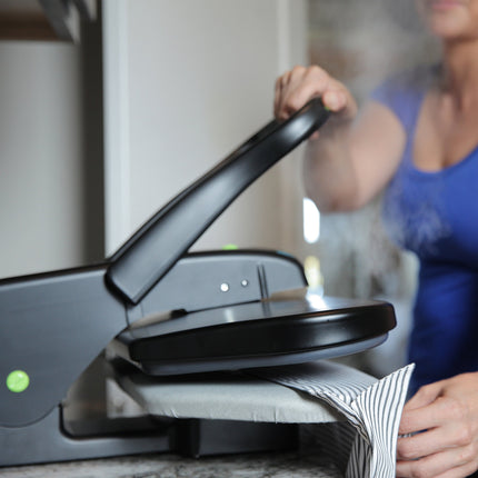 Person using a steam press with a blurred background