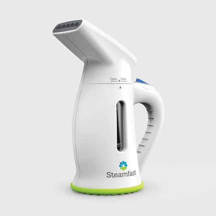 White handheld steamer with green base on a light gray background, featuring the Steamfast brand.
