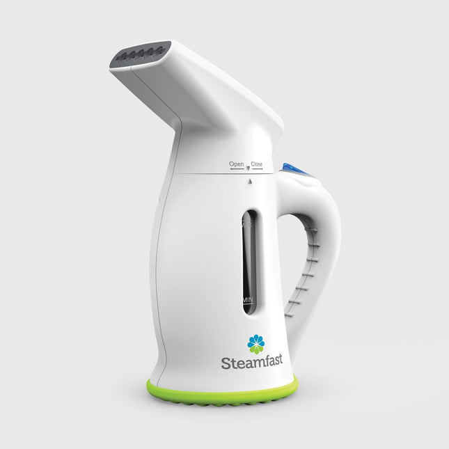 White handheld steamer with green base on a light gray background, featuring the Steamfast brand.