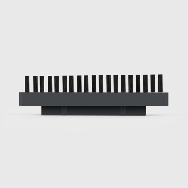 Gray brush head with black bristles on a light gray background
