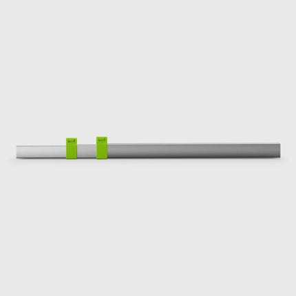 Thin metallic rod with two green markers on a light gray background