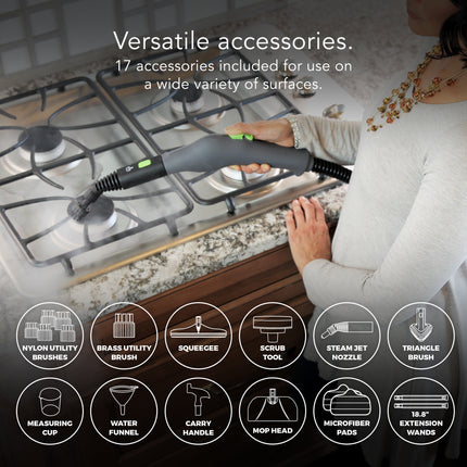 Person using a steam cleaner on a kitchen stove with various accessories displayed below.