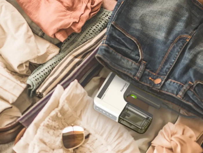 Nomad travel steamer getting packed in a suitcase.