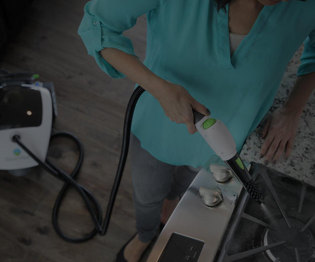 Steamfast steam cleaner being used in the kitchen on cleaning a stovetop.