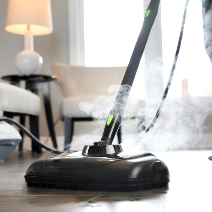 Person using a SF-375 Canister Steam Cleaner with Mop Attachment to clean wood floor.