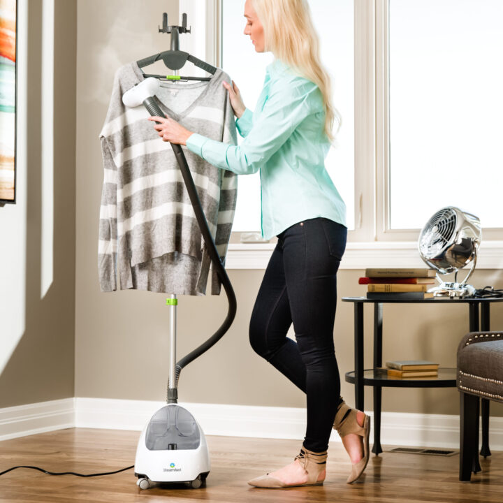 Woman using a SF-520 Full-Size Fabric Steamer on a sweater.